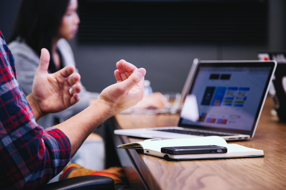 Close-up of a person's hands gesturing during a work meeting