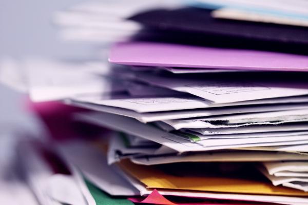 A stack of papers, documents and folders on a desk 